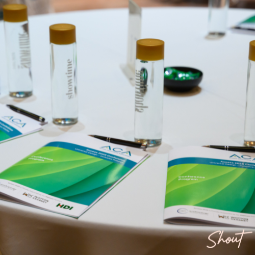 Conference table with branded water bottles and informational brochures.